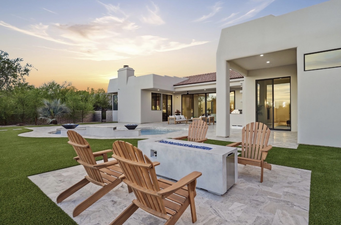 Fire pit seating on turf beside a newly built backyard pool